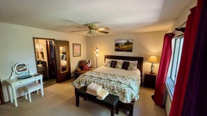 A bedroom with a bed, a desk, a chair, a bench, a ceiling fan, a lamp, and a window with curtains. - Ultimate Mountain Retreat! (South Lake Tahoe)