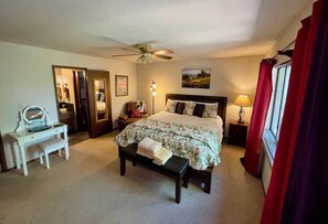 A bedroom with a bed, a desk, a chair, a bench, a ceiling fan, a lamp, and a window with curtains. - Ultimate Mountain Retreat! (South Lake Tahoe)