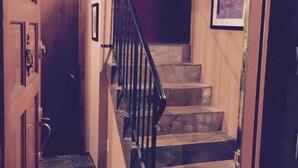 A staircase with a wooden handrail and a rug at the bottom. - Ultimate Mountain Retreat! (South Lake Tahoe)