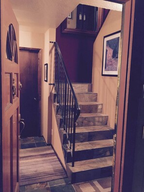 A staircase with a wooden handrail and a rug at the bottom. - Ultimate Mountain Retreat! (South Lake Tahoe)