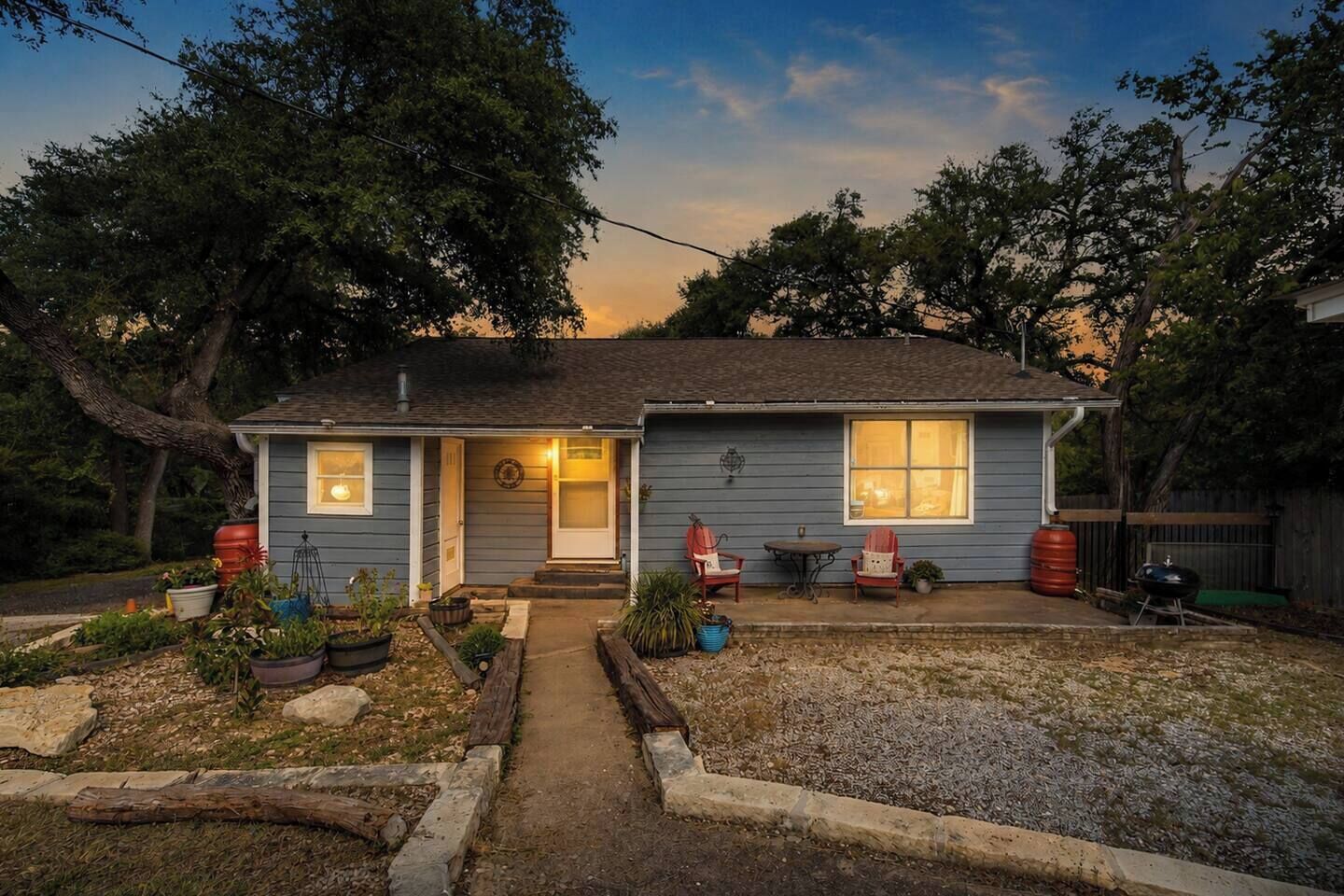 A residential house with a front porch, a small garden, and a barbecue grill.