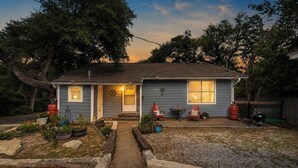 A residential house with a front porch, a small garden, and a barbecue grill.