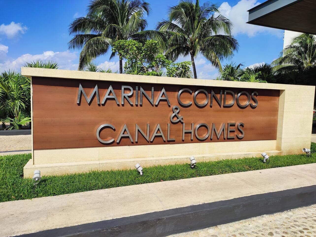 Schild mit der Aufschrift 'MARINA CONDOS & CANAL HOMES', mit freier Sicht auf den Namen der Anlage.