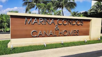 Schild mit der Aufschrift 'MARINA CONDOS & CANAL HOMES', mit freier Sicht auf den Namen der Anlage.