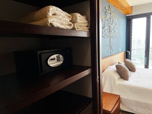Habitación de hotel con una cama, una radio y vistas a la ciudad a través del ventanal.