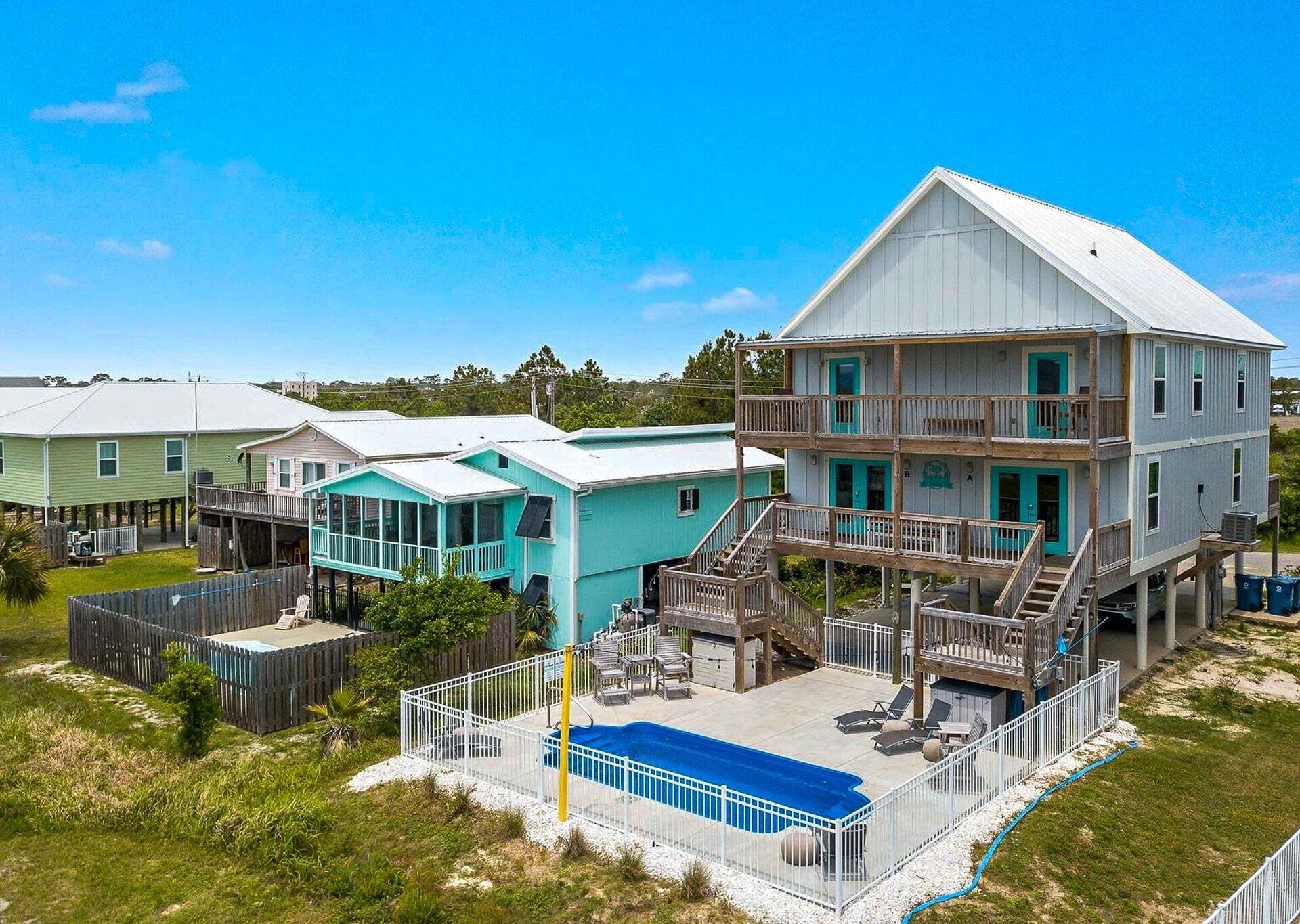 Ein mehrstöckiges Strandhaus mit Pool, mehreren Terrassen und einem großen Balkon.