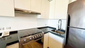 A kitchen with a stove, oven, sink, and refrigerator. - TOP/1BR/Contemporary Condo/Huge Terrace/Gym/HZ (Cancún)