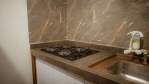 A kitchen with a gas stove, a sink, and a marble backsplash. - Apto com rea de Lazer a 15 min do Aeroporto (Manaus)