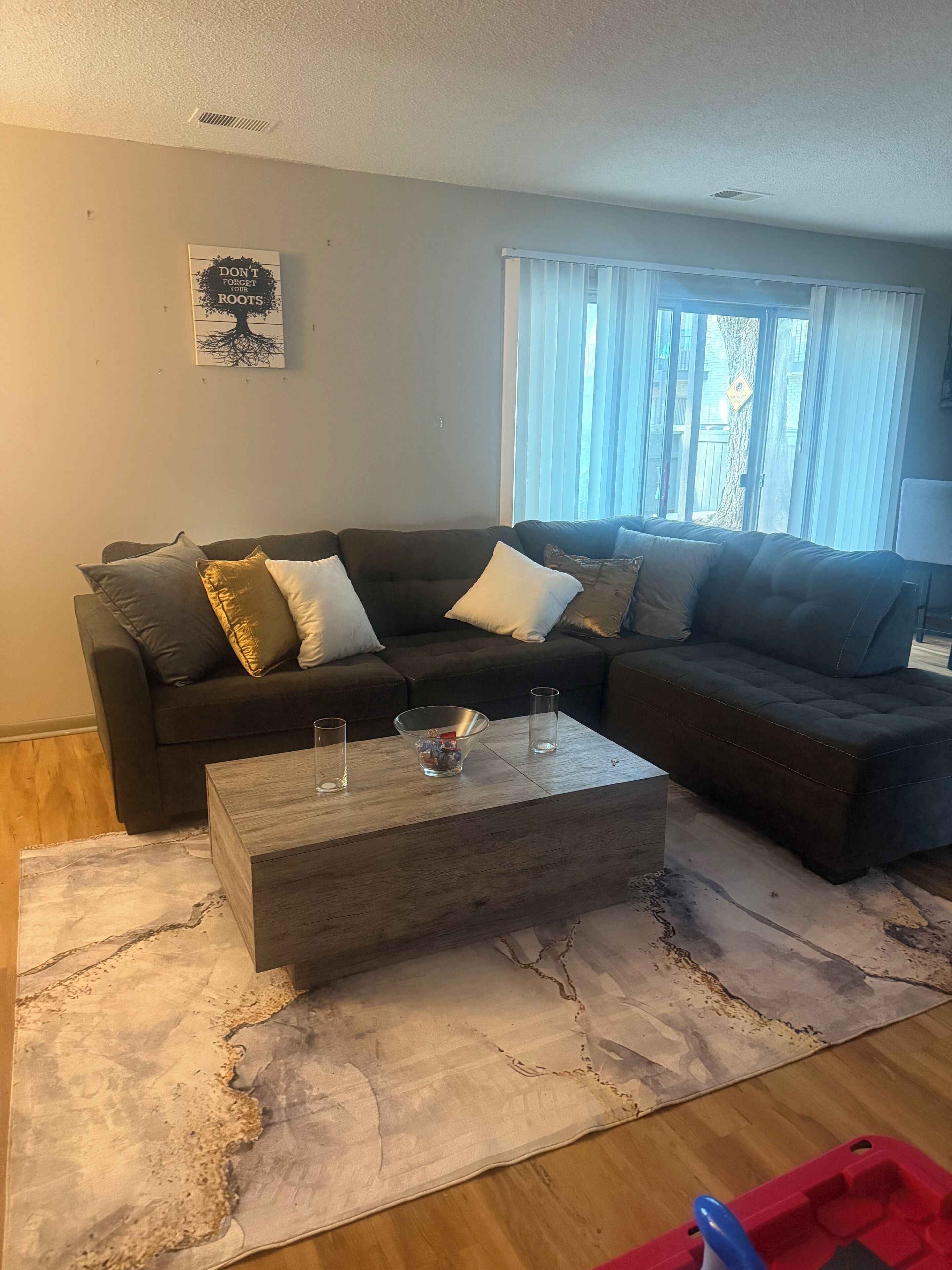 Een woonkamer met een modulaire bank, een salontafel en een vloerkleed.