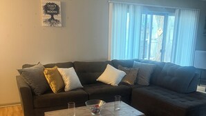 Una sala de estar con un sofá modular, una mesa de centro y una alfombra.