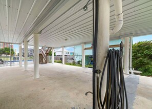 Ein überdachter Außenparkbereich mit Betonböden, Metallgeländern und einer Treppe, die zu einem Gebäude führt.