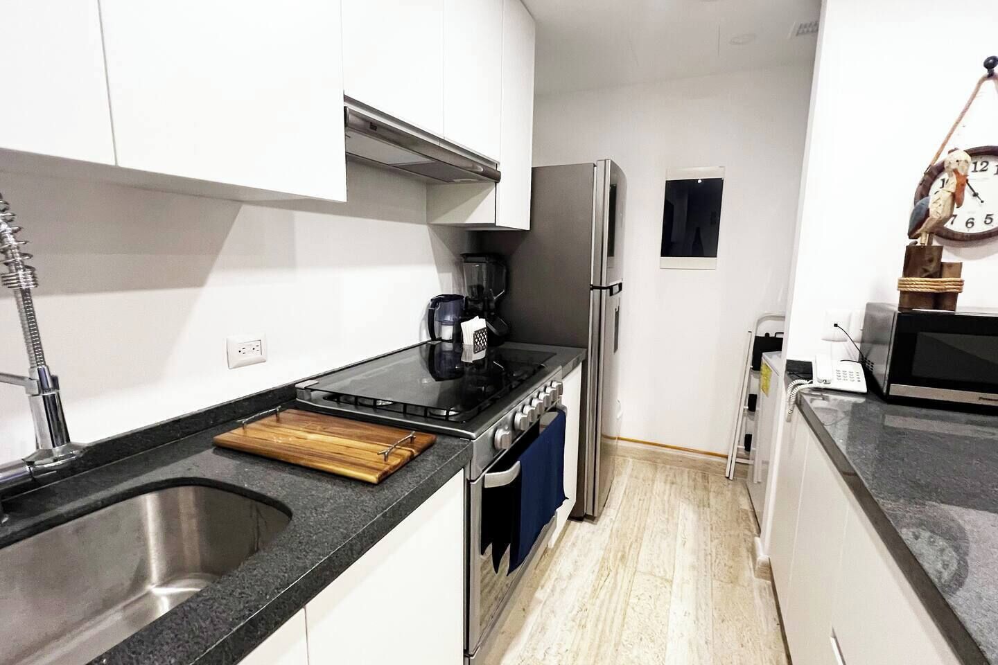 Eine kleine Küche mit Spüle, Herd und Kühlschrank.
