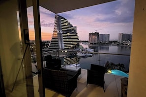 Un balcón con vistas a un edificio moderno y un puerto deportivo.