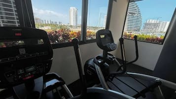 A gym with exercise equipment, a treadmill, and a stationary bike.