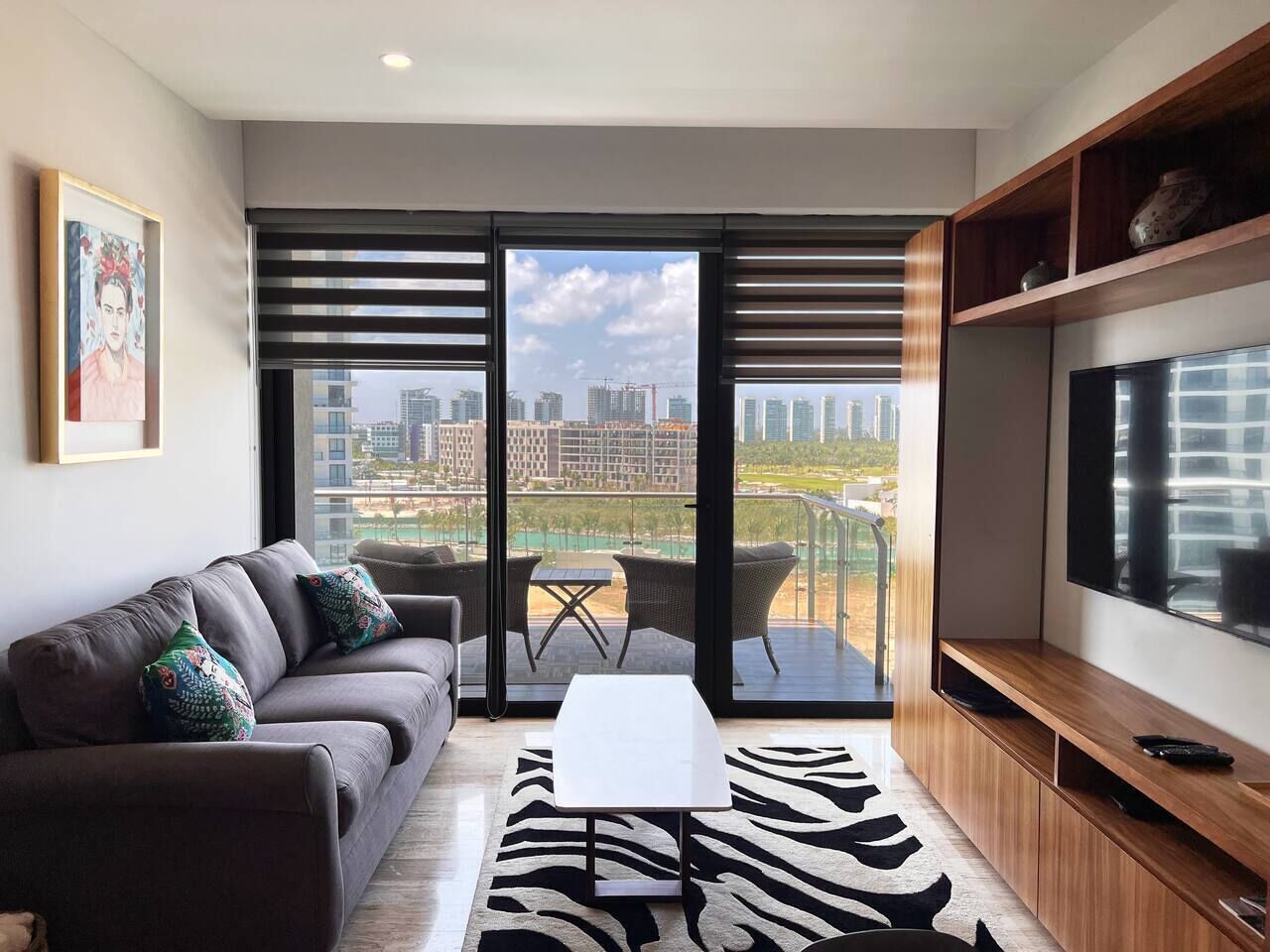 Una sala de estar moderna con un sofá, una mesa de centro y un televisor.