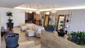 A modern living room with a sofa set, a coffee table, and a large potted plant. - TOP/ 1BR/Luxury Condo/ Ocean/Marina/Canal Views/HZ (Cancún)