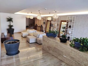 Una sala moderna con un conjunto de sofás, una mesa de centro y una planta grande en maceta.