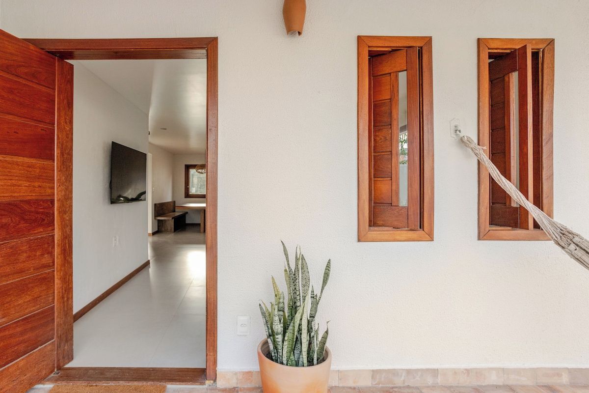A hallway with wooden doors, a potted plant, and a hammock.