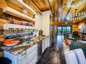 A modern kitchen with a marble countertop, stainless steel appliances, and a wine rack.