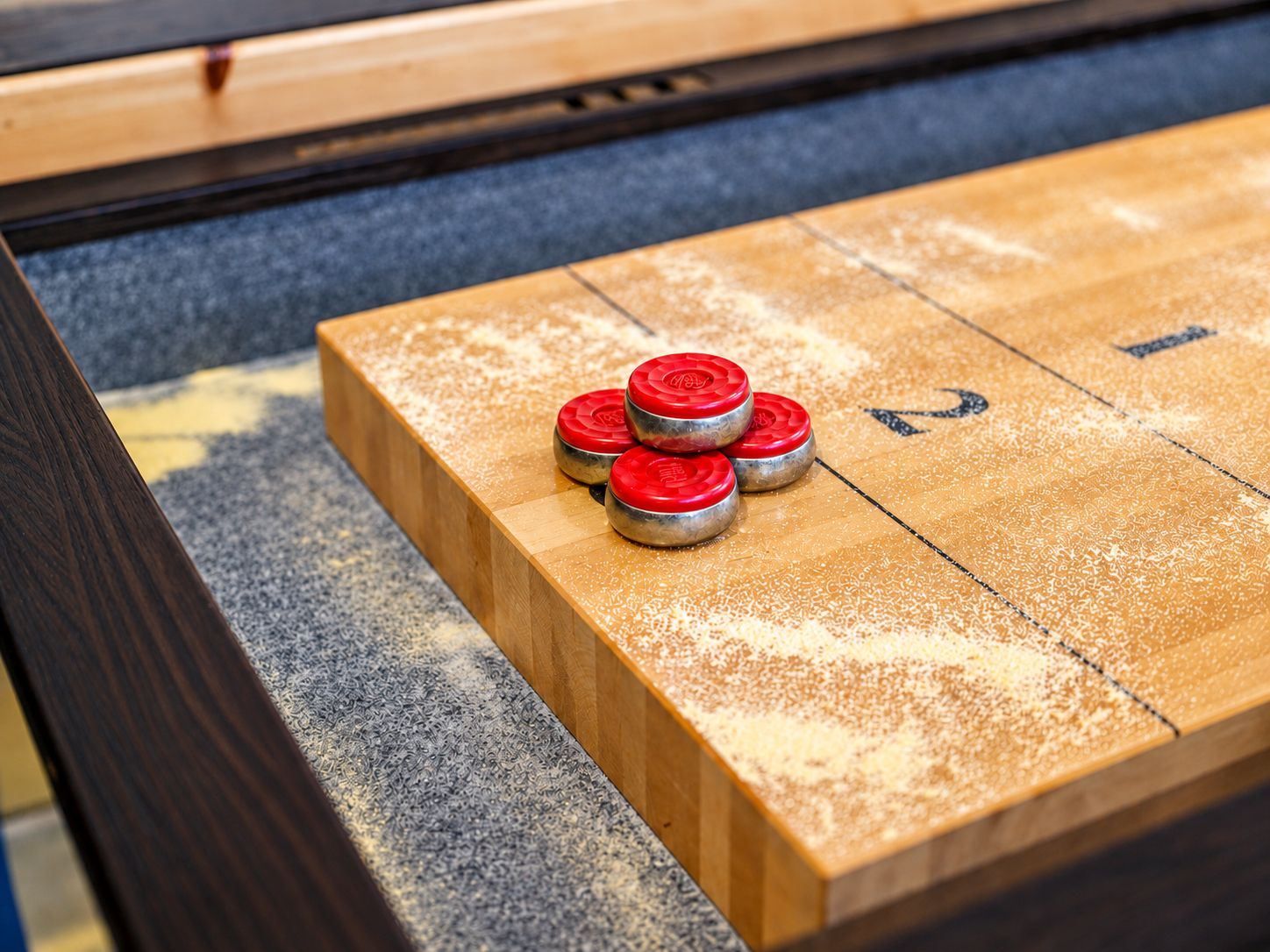Een jeu de boules tafel met genummerde vakken en schijven.