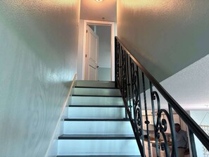 A staircase with white steps and black railings leading to a door. - Perdido Key Paradise Beachfront 3BR (Pensacola)