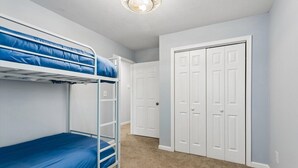 Ein Zimmer mit Etagenbetten, einer Tür und Teppichboden.