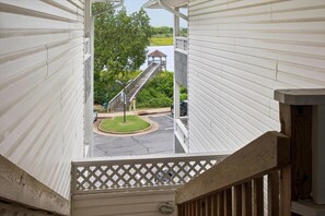 A view from a covered outdoor area with a wooden staircase leading to a gazebo. - The Cove at Mill Creek (Hampton)
