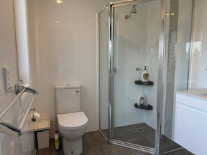Chuveiro, secador de cabelo, toalhas de banho, papel higiênico
