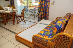 A room with a sofa, a dining table with chairs, and a balcony with a table and chairs. - Dept. Exclusive Ixtapa (Ixtapa Zihuatanejo)