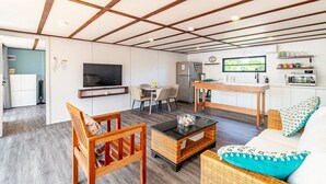 A compact living space with a television, dining area, kitchenette, and a sofa. - Secret Beach Escape with Pool! Off Season Rates! (San Pedro)