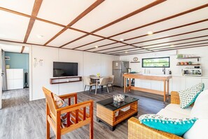 A compact living space with a television, dining area, kitchenette, and a sofa. - Secret Beach Escape with Pool! Off Season Rates! (San Pedro)