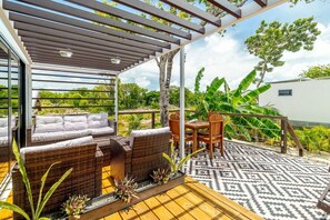 A covered outdoor seating area with wicker furniture and a patterned floor. - Secret Beach Escape with Pool! Off Season Rates! (San Pedro)