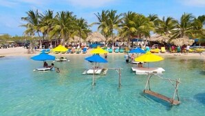 A clear blue water body with a beach and palm trees in the background. - Secret Beach Escape with Pool! Off Season Rates! (San Pedro)