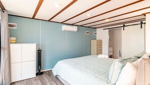 A bedroom with a bed, a wardrobe, a heater, and a wardrobe with a mirror. - Secret Beach Escape with Pool! Off Season Rates! (San Pedro)