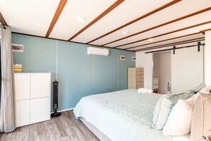 A bedroom with a bed, a wardrobe, a heater, and a wardrobe with a mirror. - Secret Beach Escape with Pool! Off Season Rates! (San Pedro)