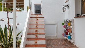 Eine weiße Treppe mit roten, sternförmigen Markierungen, die zu einer Tür mit einem Fenster führt.