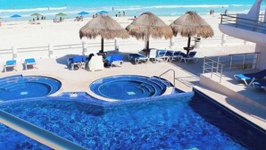 A pool area with multiple hot tubs and lounge chairs, overlooking a beach. - TOP/3BR/First Line Ocean Front Villa/2 Terrace/HZ (Cancún)