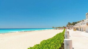 A beachside hotel with a clear view of the ocean, a sandy beach, and a row of buildings with a uniform architectural style. - TOP/3BR/First Line Ocean Front Villa/2 Terrace/HZ (Cancún)