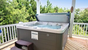 A hot tub on a wooden deck with a white railing, surrounded by greenery. - Oceanside, 2 Hot Tubs- 2 Duplex's rents as 1-BU22, Love R Shack at the Beach (Corolla)