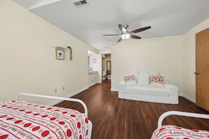 A bedroom with a bed, a ceiling fan, and a wooden door.