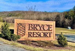 A wooden sign with 'Bryce Resort' written on it, surrounded by small bushes and trees. - Newly Renovated Slopeside Condo at Bryce Resort. Family and pet-friendly! (Mount Jackson)