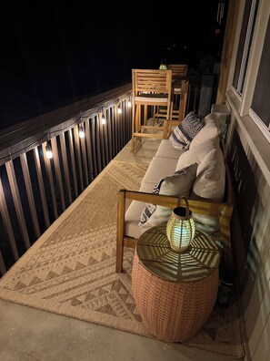 A balcony with a sofa, a chair, a small table, and a lamp. - Newly Renovated Slopeside Condo at Bryce Resort. Family and pet-friendly! (Mount Jackson)