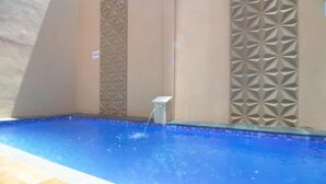 Une piscine dont les murs sont décorés de motifs géométriques en carreaux.