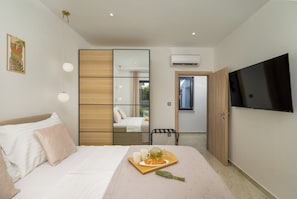 A modern bedroom with a bed, bedside table, and a TV mounted on the wall. - Villa Lenko (Istria - Svetvinčenat) (Svetvinčenat)