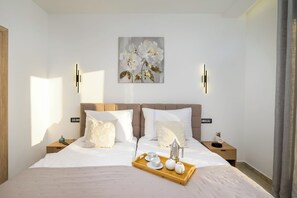 Ein modernes Schlafzimmer mit einem großen Bett, zwei Nachttischen, einer Wandleuchte und einem Gemälde über dem Bett.