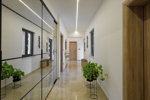 A modern hallway with glass partitions, wooden flooring, and potted plants. - Villa Lenko (Istria - Svetvinčenat) (Svetvinčenat)