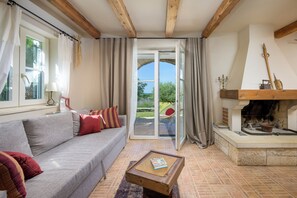 Una sala acogedora con un sofá gris, una mesa de centro de madera y una chimenea.
