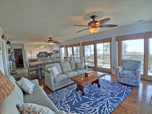 A spacious living area with a sofa, coffee table, and a patterned rug. - Kismet - Oceanfront in Garden City Beach (Garden City Beach)