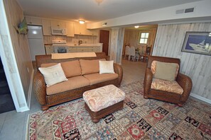 A living room with a sofa, two armchairs, a coffee table, and a patterned rug. - Kismet - Oceanfront in Garden City Beach (Garden City Beach)