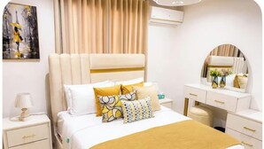 Een hotelkamer met een bed, nachtkastjes, een dressoir en een spiegel.
